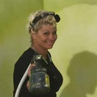 A woman holding a hose and spray bottle.